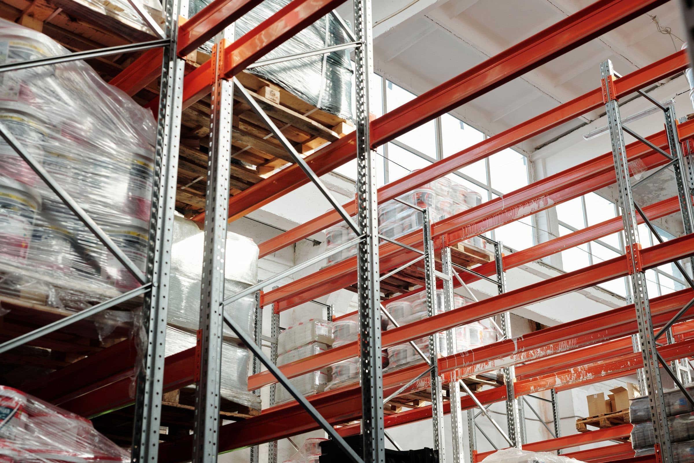 Scaffalature industriali con bancali avvolti nel film in un magazzino luminoso